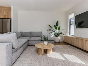 a living room with a couch and a coffee table at Black Wattle Beach House in Casuarina