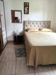 a bedroom with a large bed and a mirror at Ospedagem leão in Praia Grande