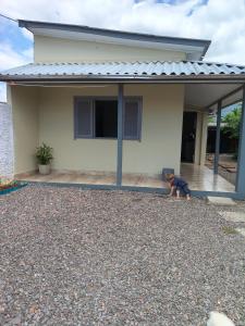 a small child sitting on the porch of a house at Ospedagem leão in Praia Grande