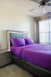 a purple bed in a room with a window at Cozy & inviting 2BD 2BTH Apt Home in Owings Mills