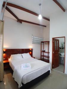 a bedroom with a large bed and a bathroom at HEYSEN Haus in Tarapoto