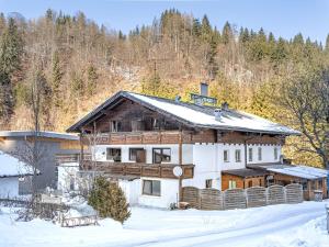 a large wooden house in the snow with trees at Grieswirt L in Itter