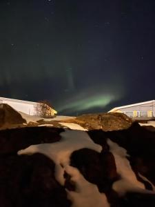 a reflection of the aurora in a pool of water at night at Homestay Snæfellsnes in Stykkishólmur