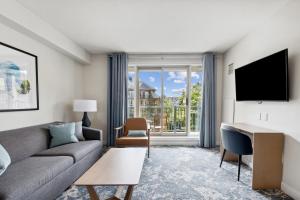 a living room with a couch and a desk and a television at Blue Mountain Resort Village Suites in Blue Mountains