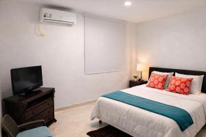 a bedroom with a bed and a flat screen tv at Posada Lkjay Providencia Isla in Providencia