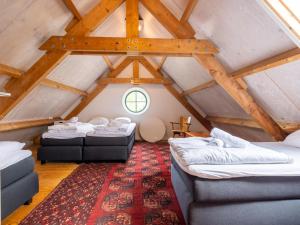 a attic room with two beds and a rug at De Schuur in Kaag