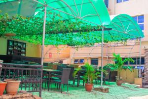 a patio with tables and chairs and an umbrella at Beulah House Lounge in Ibadan