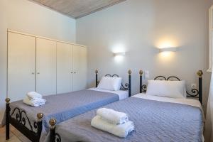 two beds sitting next to each other in a bedroom at Villa Helona in Keri +24 photos