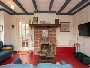 a living room with a fireplace and a blue couch at Zandkamer in Vrouwenpolder