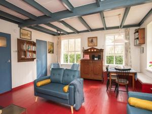 a living room with a blue couch and a table at Zandkamer in Vrouwenpolder