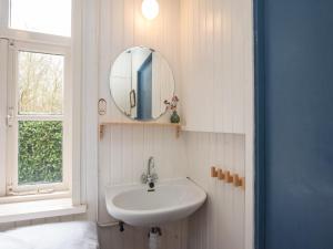 a bathroom with a sink and a mirror at Zandkamer in Vrouwenpolder +30 photos