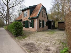 a brick house with a green roof and a driveway at Zandkamer in Vrouwenpolder