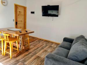 a living room with a couch and a table at Cabañas Lagos y Volcanes in Coñaripe