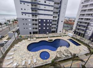 a swimming pool in front of a tall building at Piscina Lazer Frente ao Mar in Mongaguá