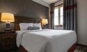 a bedroom with a large white bed and two lamps at Blue Mountain Resort Village Suites in Blue Mountains +100 photos