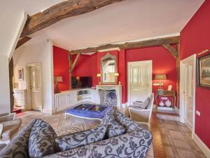 a living room with red walls and a couch at Erve Het Klaashuis in Deurningen