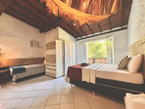 a bedroom with a bed and a tub in a room at Palmares, Casa Rustica Suites Buzios in Búzios +29 photos