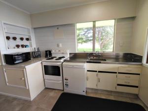a kitchen with a sink and a stove at Te Ra Waitangi in Paihia