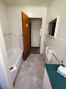 a bathroom with a tub and a toilet and a sink at Te Ra Waitangi in Paihia +19 photos