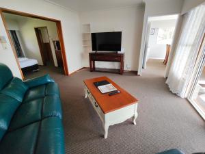 a living room with a couch and a coffee table at Te Ra Waitangi in Paihia