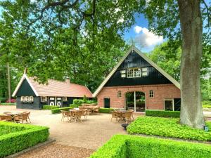 a building with tables and chairs in front of it at Erve Het Klaashuis in Deurningen