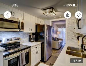 a kitchen with white cabinets and a stainless steel refrigerator at Pet Friendly | Pool | Tennis | Walk to Shops in Hilton Head Island