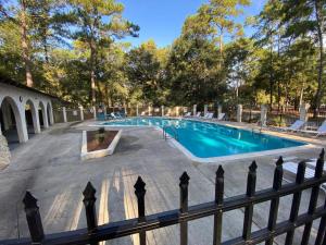 a swimming pool with chairs and a fence at Pet Friendly | Pool | Tennis | Walk to Shops in Hilton Head Island