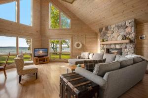 a living room with a couch and a stone fireplace at Cozy A Frame Waterfront Chalet Dock Fireplace in Traverse City