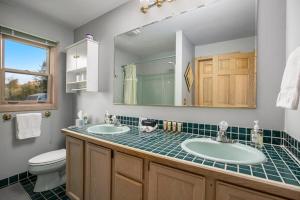 a bathroom with two sinks and a toilet and a mirror at Cozy A Frame Waterfront Chalet Dock Fireplace in Traverse City +100 photos