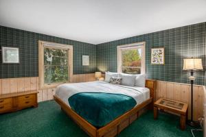 a bedroom with a large bed and two windows at Cozy A Frame Waterfront Chalet Dock Fireplace in Traverse City