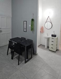 a dining room with a black table and chairs and a sink at Casa Completa em Cotia com estacionamento in Cotia