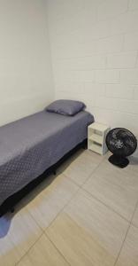 a bedroom with a bed and a night stand at Casa Completa em Cotia com estacionamento in Cotia
