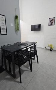 a black table and two chairs in a room at Casa Completa em Cotia com estacionamento in Cotia