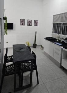 a kitchen with a table and chairs in a room at Casa Completa em Cotia com estacionamento in Cotia +17 photos