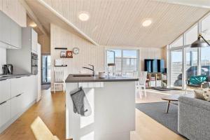 a kitchen and living room with a kitchen island in a house at 30434-Odder-Strandvaenget-10 in Odder