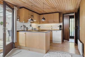 a large kitchen with wooden cabinets and appliances at 30486-Odder-Kirkeager-5 in Odder +20 photos