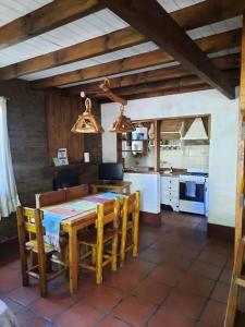 a kitchen with a wooden table and chairs in a room at Cabañas Blumenhaus in Villa Ventana