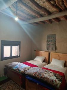 a bedroom with two beds in a room at Auberge Restaurant Oumidou in Agoudal