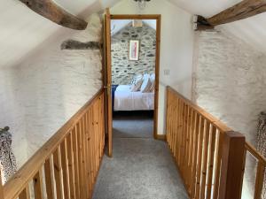 a staircase leading to a bedroom with a bed in a room at Tithe Barn 1 - Abercelyn Cottages - Llanycil - Bala - Gwynedd - LL23 7YF - UK in Llanycil