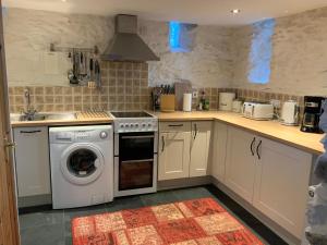a kitchen with a washer and dryer in it at Tithe Barn 1 - Abercelyn Cottages - Llanycil - Bala - Gwynedd - LL23 7YF - UK in Llanycil