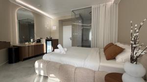 a bedroom with a white bed and a couch at קו המים - Waterline סוויטות עם גקוזי הכי קרוב לים in Netanya