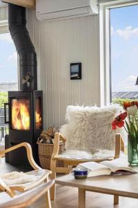a living room with a fireplace and a table with a book at 30467-Odder-Ravnsager-15 in Odder