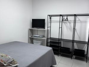 a bedroom with a bed and a tv on a shelf at Apartamento da Rosa Rua Epaminondas Otoni Número 777 in Teófilo Otoni