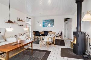 a living room with a fireplace and a table at 30320-Odder-Violvej-15 in Odder