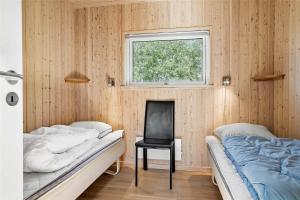 a bedroom with two beds and a chair and a window at 30460-Odder-Strandvaenget-16 in Odder