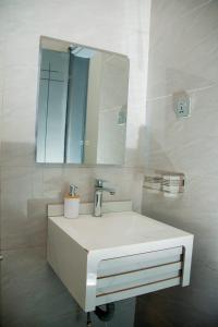 a bathroom with a white sink and a mirror at Ham Homes in Kampala +46 photos