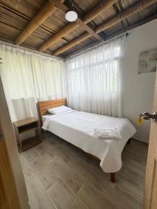 a bedroom with a bed and a window at Hospedaje Finca Eje Cafetero, Casa Ne u in Marsella