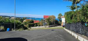 an empty street in a residential neighborhood with a fence at Mansio Awatere in Snells Beach