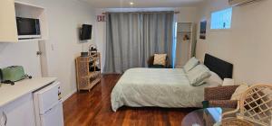 a small bedroom with a bed and a tv at Mansio Awatere in Snells Beach