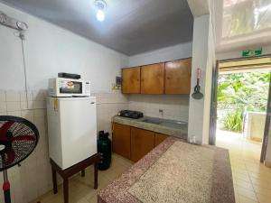 eine kleine Küche mit Kühlschrank und Mikrowelle in der Unterkunft Bread Fruit Lodge in San Andrés